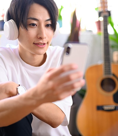 オンラインギターレッスンを受講する男性|動画見放題プラン